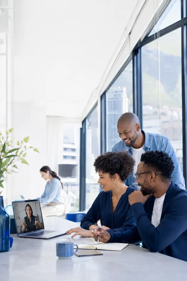 Office team collaborating across desk and remote work